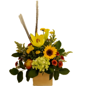 Bouquet of yellow and orange flowers accented with wheat stems and faux fruit arranged in a natural wood box.