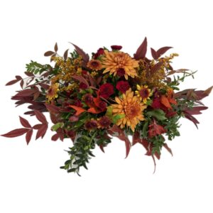 Warm Autumn colors harmonize in this design of chrysanthemums, mini-carnations and a variety of seasonal flowers and foliage. Perfect for a dining room table.