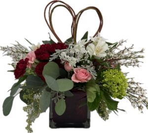 Red cube vase with hydrangea, burgundy carnations, Pink spray roses, with white accents and a heart