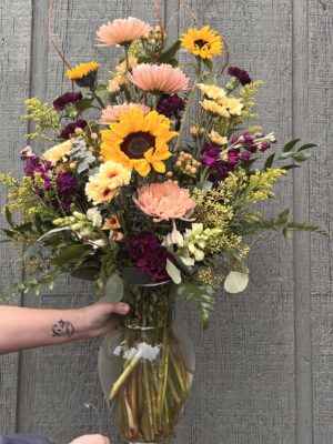 Vase arrangement with sunflowers, colorful mums, stock and solid aster